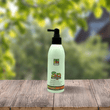 Cargar imagen en el visor de la galería, Spray protector que aporta brillo en bote blanco y etiqueta de colores naranjas y verdes en un fondo con arboles