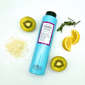 Champu sin sulfatos para color COLOR BREEZE SHAMPOO tumbado en el suelo rodeado de una rama de romero, dos mitades de kiwi, dos gajos de limon y un puñado de arroz blanco