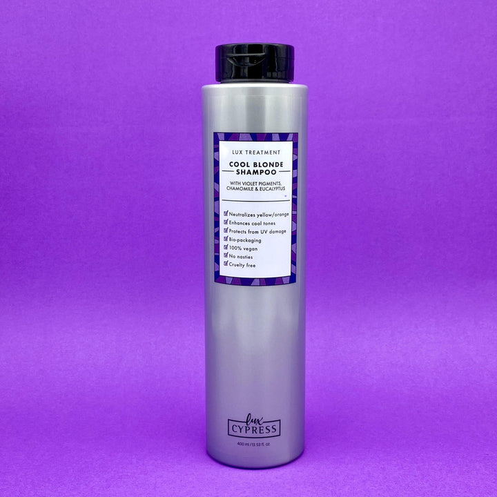 Champu violeta COOL BLONDE SHAMPOO para cabellos rubios con el bote de color lateado y etiqueta blanca con bordes de diferentes tonos de violeta, tapa negra